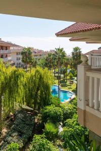 - une vue sur la piscine depuis le balcon d'un bâtiment dans l'établissement MalagaSuite Higueron Sport Club&Pool, à Fuengirola