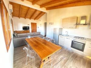 a kitchen with a wooden table and a couch at Pettirosso 6 in San Teodoro