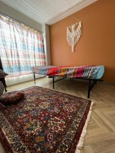 sala de estar con 2 camas y alfombra en Hostel UND BASE, en Saiki