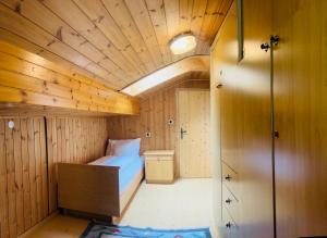 1 dormitorio con 1 cama en una habitación con paredes de madera en Park Hotel Faloria, en Canazei