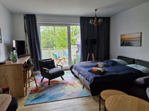 a bedroom with a bed and a living room at Ferienwohnung Ostseegras Markgrafenheide, 350m bis zur Ostsee, unweit von Warnemünde in Rostock