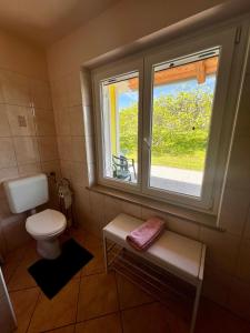 La salle de bains est pourvue de toilettes et d'une fenêtre. dans l'établissement Na kmetiji s konji - Pogelšek, à Ankaran