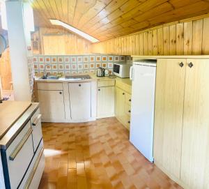 una cucina con armadi in legno e frigorifero bianco di Park Hotel Faloria a Canazei