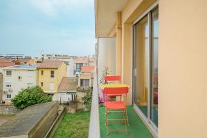 a balcony with two red chairs and a yellow table at Côté Sud in Palavas-les-Flots +30 photos