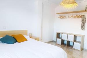1 dormitorio con cama blanca y armario de madera en Casa Maui: Apartamento para 6 con piscina, en San Mamés de Meruelo
