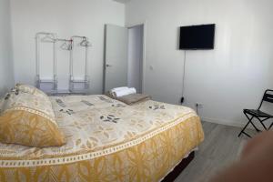 um quarto com uma cama e uma televisão de ecrã plano em Home Jv 1 em Getafe