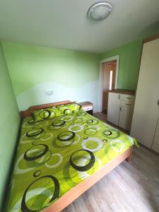 - une chambre avec un lit doté d'une couette jaune et verte dans l'établissement Na kmetiji s konji - Pogelšek, à Ankaran
