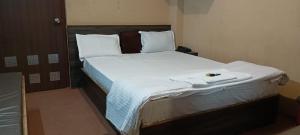 a bedroom with a large bed with white sheets at HOTEL RATNA in Darjeeling
