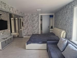 1 dormitorio con 1 cama y 1 sofá en Сдаётся однокомнатная квартира возле озера, en Baljash