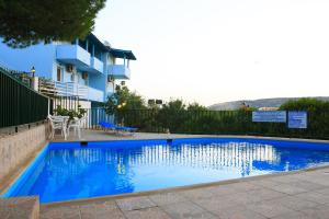 uma piscina azul em frente a um edifício em Stroubis Studios I em Megás Limniónas