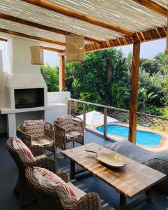 a patio with a table and chairs and a pool at Woodlands Beach Villa in Southbroom