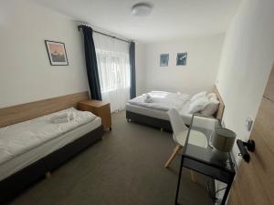 1 dormitorio con 2 camas, escritorio y mesa en Penzion Pivovar 66, en Česká Lípa