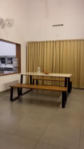 stół i ławka w pokoju w obiekcie CuteHug Home stay w mieście Kalpatta