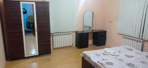 a bedroom with a bed and a dresser and a mirror at Sərin göl istirahət mərkəzi in Quba