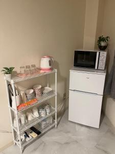 a kitchen with a microwave on top of a refrigerator at 幸 in Osaka