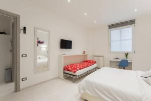 a white bedroom with a bed and a mirror at RomeEyes2020 in Rome