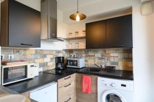 a kitchen with a washer and a sink and a microwave at Côté Sud in Palavas-les-Flots