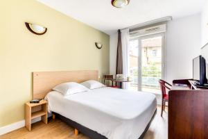 1 dormitorio con cama, escritorio y ventana en Zenitude Hôtel-Résidences Béziers Centre en Béziers