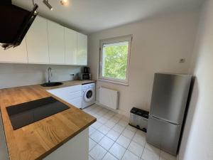 a kitchen with a stainless steel refrigerator and white cabinets at Am Ring Monteurzimmer Apartment Böhlen in Böhlen