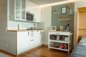 - une petite cuisine avec des placards blancs et un four micro-ondes dans l'établissement Appartement Honey, à Sankt Englmar