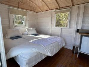 2 camas en una habitación con 2 ventanas en Lõunaranna Harbour Accommodation, en Simisti