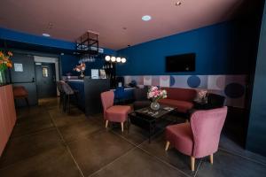 a room with a couch and chairs and a bar at Eleven by Warren Collection in Sliema