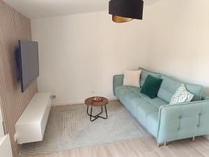 a living room with a blue couch and a table at Maison proche Paris. in Saint-Denis