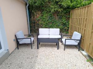 a group of three chairs sitting next to a fence at Maison proche Paris. in Saint-Denis