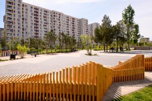 a yellow fence in front of a large building at Smart Concept Living Plaza in Bucharest