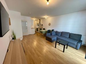 a living room with a blue couch and a table at Spacious 1BR Apartment with Balcony above Citygate Shopping Complex with Metro Access in Vienna