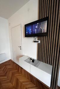 a living room with a tv on a wall at Apartman RISTIC in Vranje