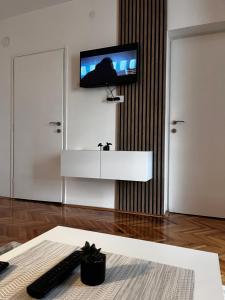 a living room with a tv on a wall at Apartman RISTIC in Vranje