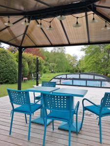 una mesa azul y sillas bajo una sombrilla en una cubierta en le buisson de la gariole ,chambre rhétaise, en Aubigny-sur-Nère