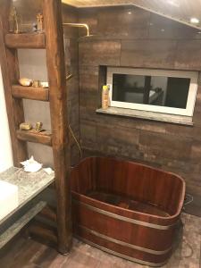 a bath tub in a room with a tv on a wall at Super Nice House In The Harbor Town Of Hvalpsund, in Farsø