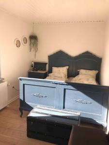 - une chambre dotée d'un grand lit avec un cadre bleu dans l'établissement Super Nice House In The Harbor Town Of Hvalpsund,, à Farsø