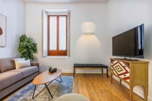 uma sala de estar com um sofá e uma televisão de ecrã plano em Bellas Artes en Madrid em Madri