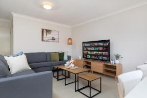 un salon avec un canapé bleu et une télévision dans l'établissement Parking! Netflix! Air-con! Convenient! SuperHost!, à Brisbane