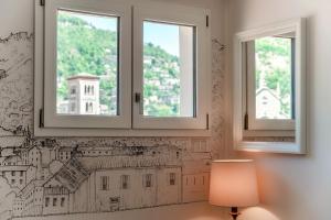 Una habitación con dos ventanas con un dibujo en la pared. en Casa Luna by Quokka 360 - Como Cathedral and city view, en Como