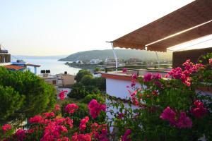 a view of the ocean from a house with pink flowers at Stroubis Studios I in Megás Limniónas