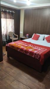 a bedroom with a large bed with a red blanket at Misty Meadows in Ooty