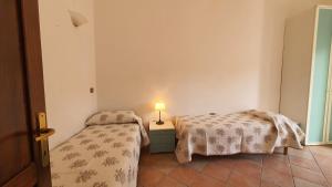a bedroom with two beds and a lamp on a table at Porto Pollo, Il borgo villetta 3 camere da letto in Porto Pollo