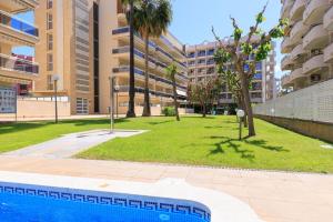 a swimming pool in the middle of a park with buildings at Ventura 1 Planet Costa Dorada in Salou