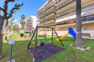 a playground in a park next to a building at Ventura 1 Planet Costa Dorada in Salou