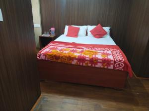 een slaapkamer met een bed met een rode deken bij Misty Meadows in Ooty