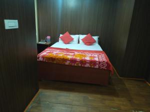 - une chambre avec un lit et une couette rouge dans l'établissement Misty Meadows, à Ooty
