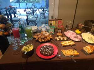 une table avec des assiettes de nourriture dans l'établissement BHL Boutique Rooms Legnano, à Legnano