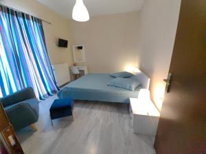 a bedroom with a bed and a couch and a chair at Family Holiday House In Nafplio in Nafplio