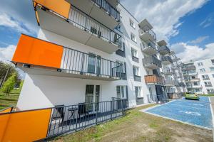 an apartment building with balconies and a parking lot at Stara Piekarnia - Kołobrzeska in Olsztyn