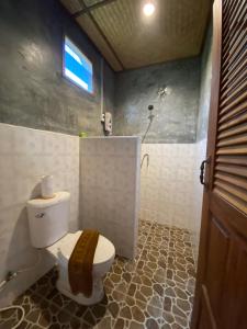 a bathroom with a toilet and a shower with a window at Pai Smilehouse in Pai