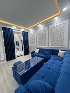 una sala de estar con sofás azules y una mesa. en My_willa_Buzovna, en Zağulba Bağları